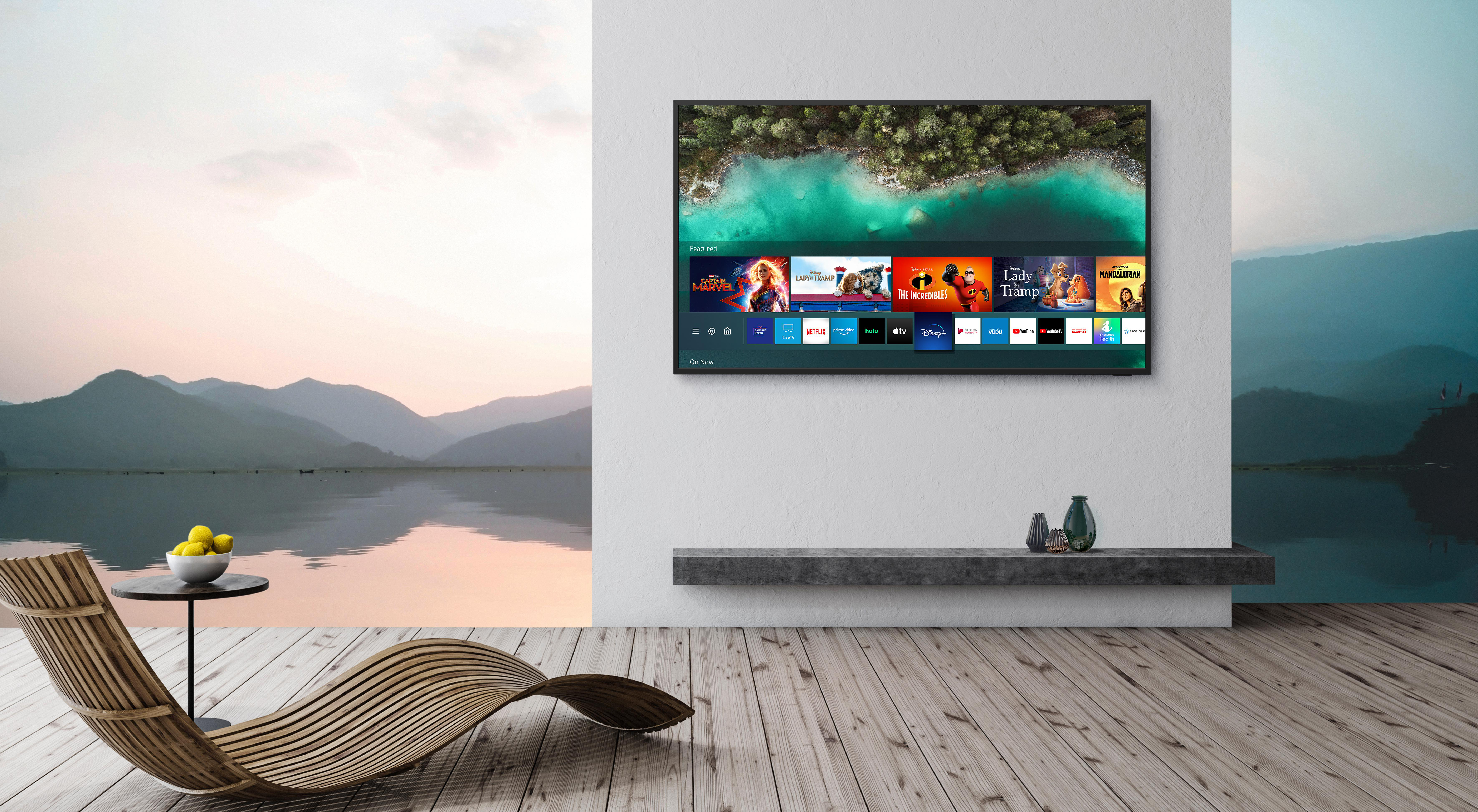 Fernseher mit Naturszene, Liegestuhl, Beistelltisch mit Zitronen und Seeblick.