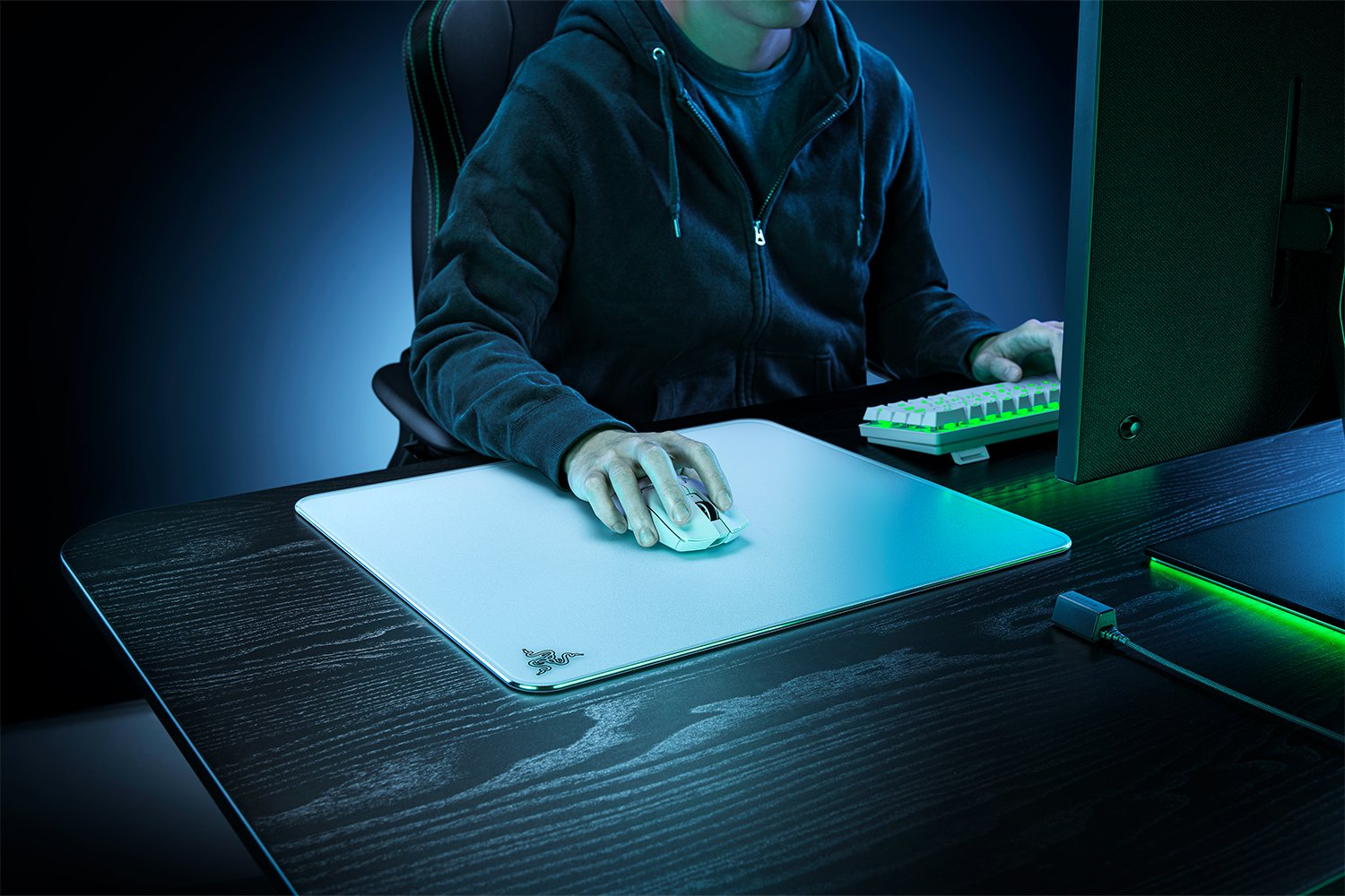 Person benutzt weiße Maus auf weißem Mauspad. Sie befinden sich in einem dunklen Raum mit Computer.