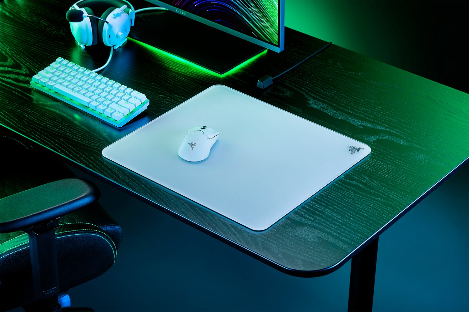Ein Schreibtisch-Setup mit weißer Maus und Pad, Kopfhörern und Tastatur.