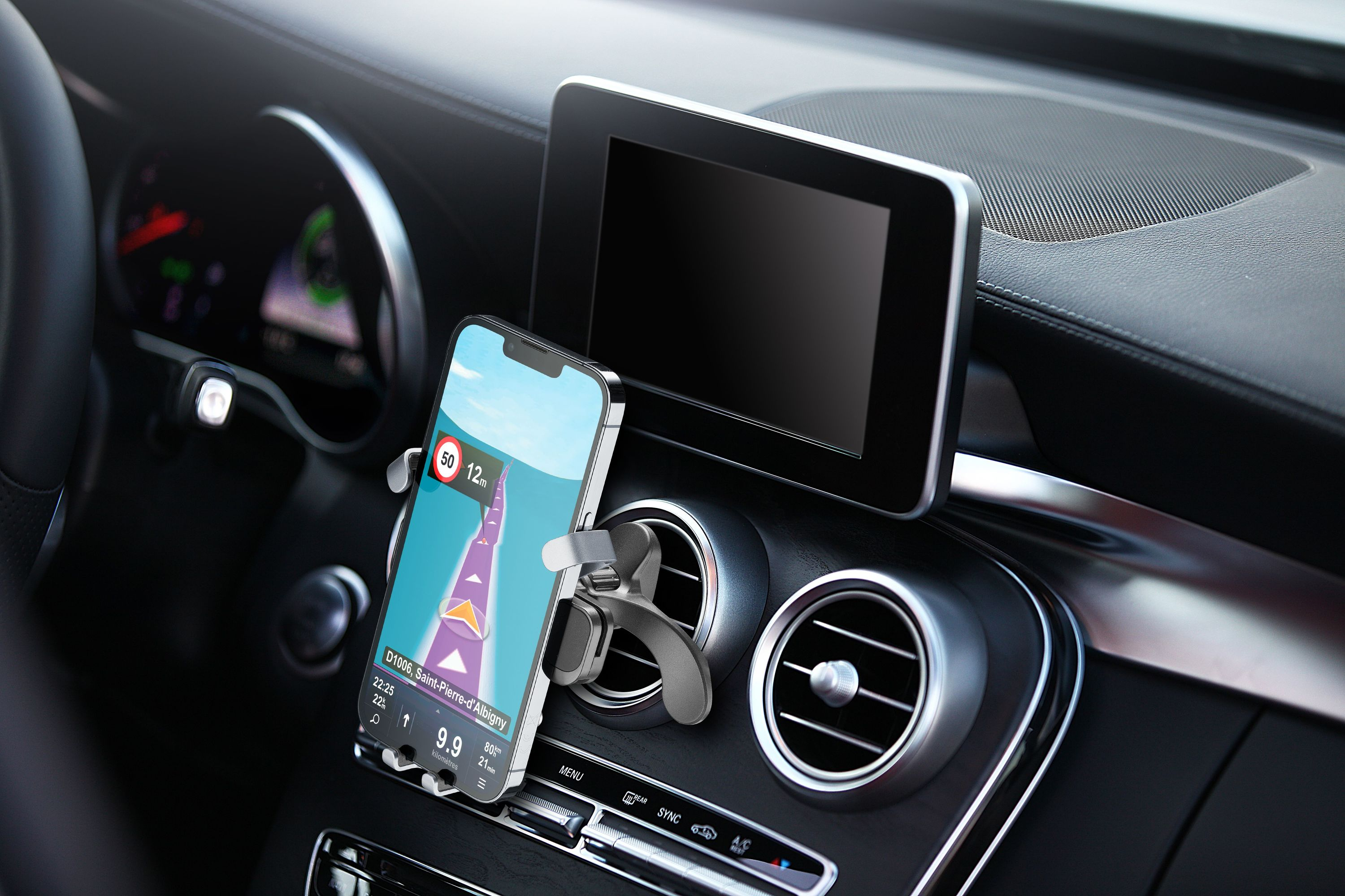 Ein Smartphone in einer Autohalterung zeigt eine Navigations-App. Ein modernes Autointerieur ist sichtbar.