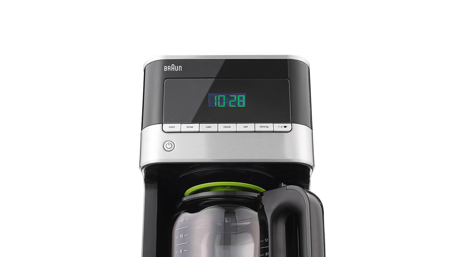 Nahaufnahme eines schwarzen und silbernen Braun Kaffeeautomaten. Die Uhrzeit 10:28 wird grün angezeigt.