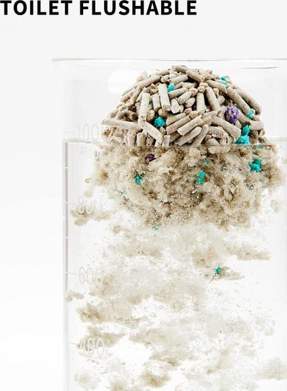 Un becher in vetro con una sostanza bianca che si scioglie in acqua. Il testo "TOILET FLUSHABLE" è sopra.