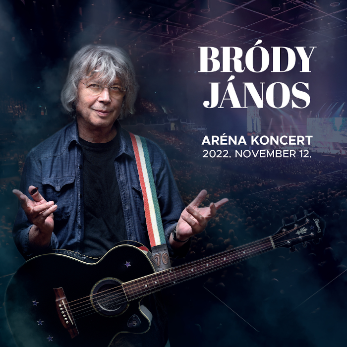 Férfi gitárral. Szöveg: Bródy János, Aréna Koncert 2022. november 12. Színpadi fények a háttérben.