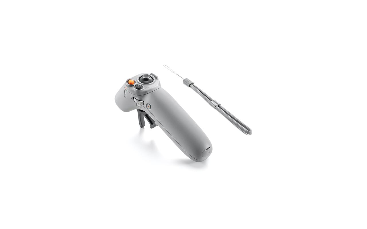 Grauer Drohnen-Controller mit Handschlaufe, auf weißer Oberfläche.
