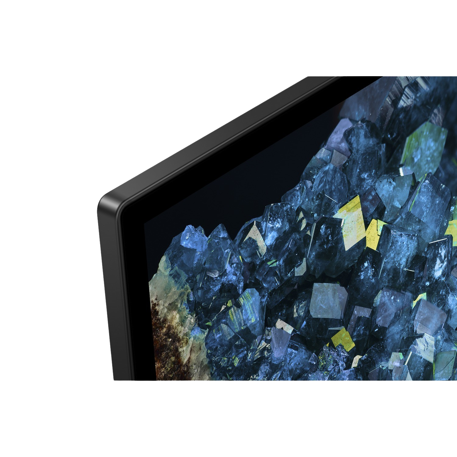Close-up of a black monitor's corner. The screen displays a colorful, abstract, crystalline pattern.
