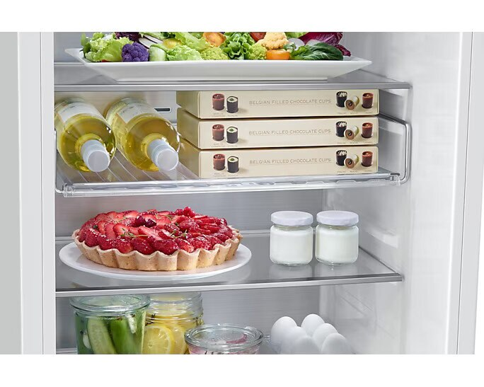 W lodówce: sałatka, wino, filiżanki czekoladowe, tarty truskawkowe, jogurt i inne produkty. Dobrze zaopatrzona i schludnie ułożona.