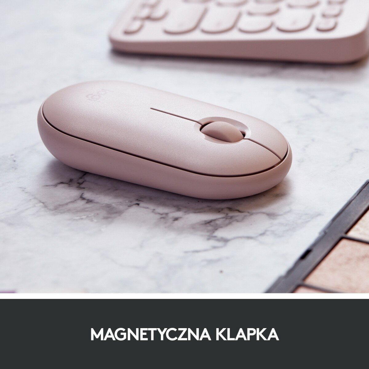 Różowa mysz bezprzewodowa na marmurowej powierzchni z klawiaturą w tle.