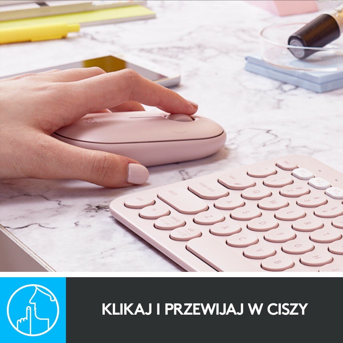 Dłoń używająca różowej myszy obok klawiatury na marmurowej powierzchni.