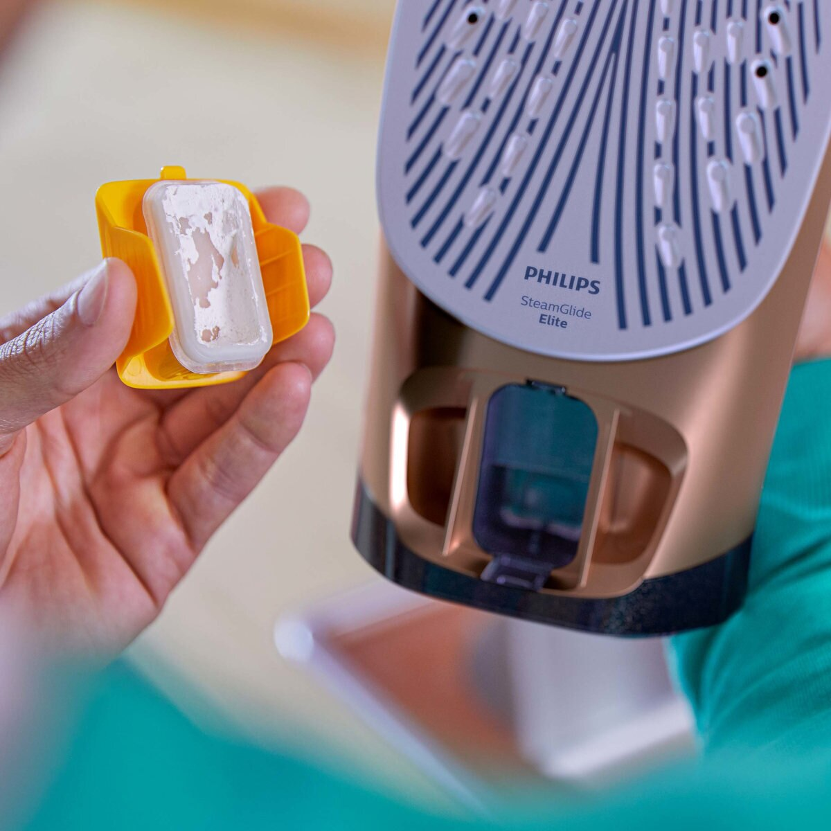 Żelazko z brązowym korpusem, żółtym uchwytem. Filtr jest usunięty.