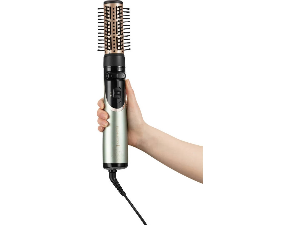 Una mano sosteniendo un cepillo para peinar el cabello, con un cable negro y fondo blanco.