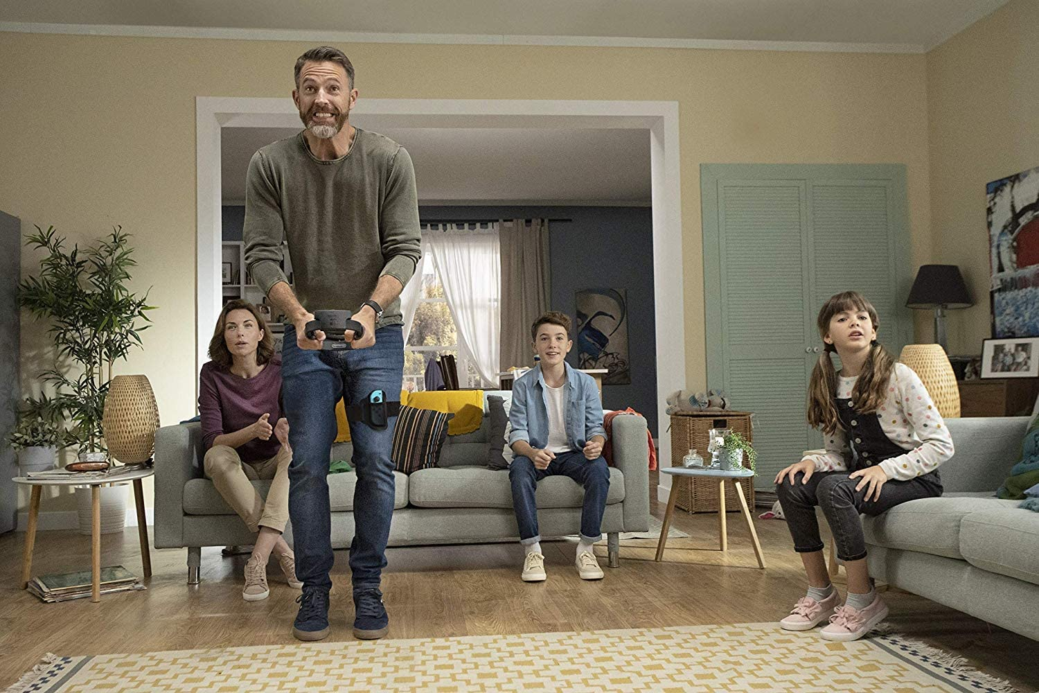 Een gezin speelt een videospel in een woonkamer.