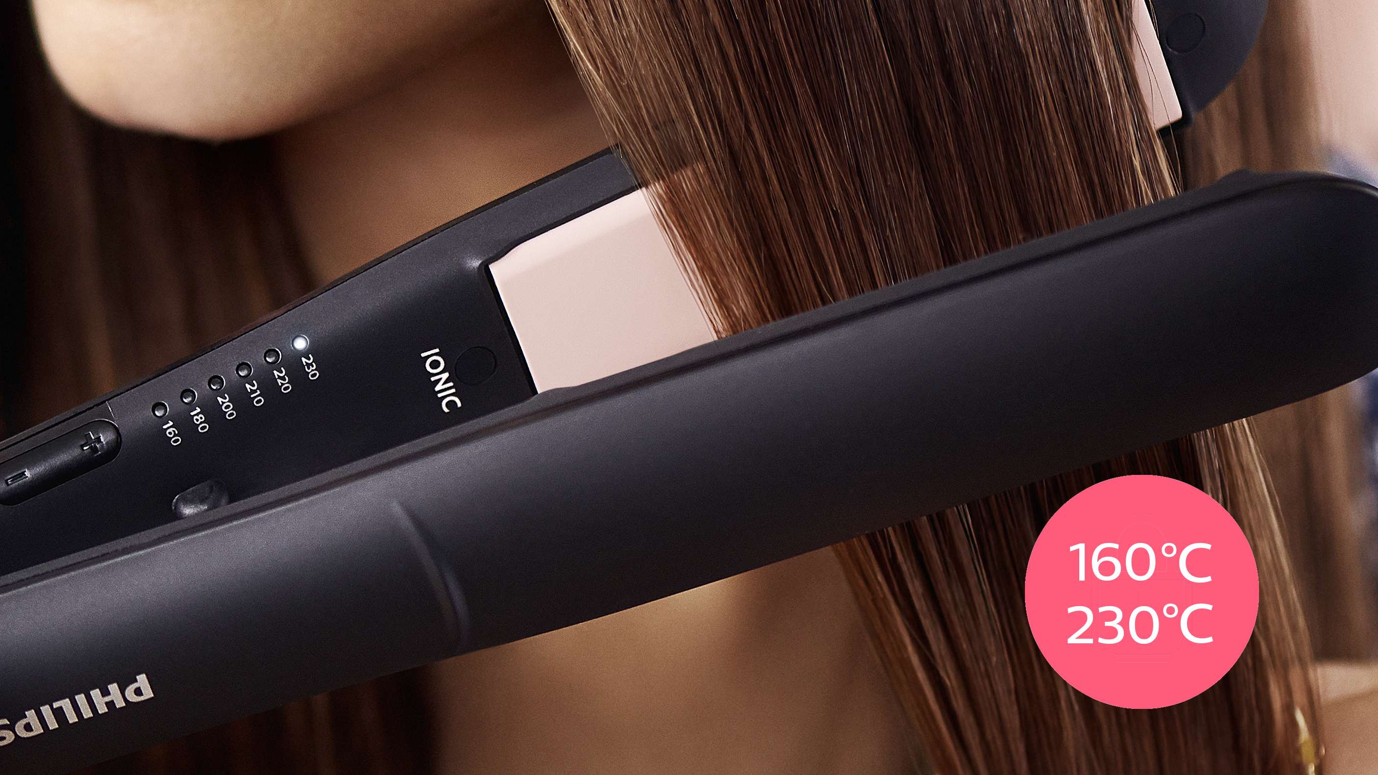 Mujer alisando el cabello con una plancha negra y rosa.