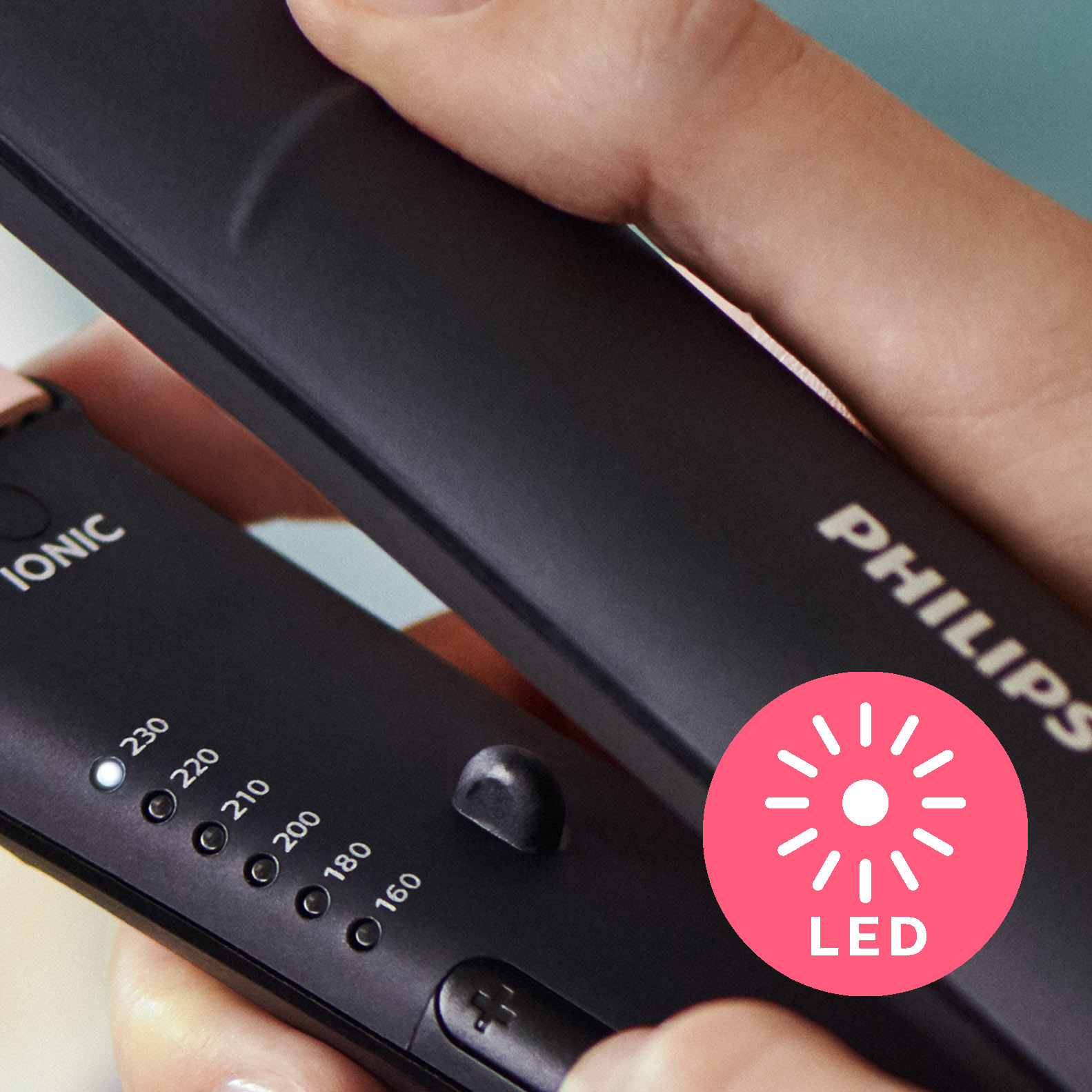 Primer plano de una plancha de pelo Philips negra con indicador LED y ajustes de temperatura.