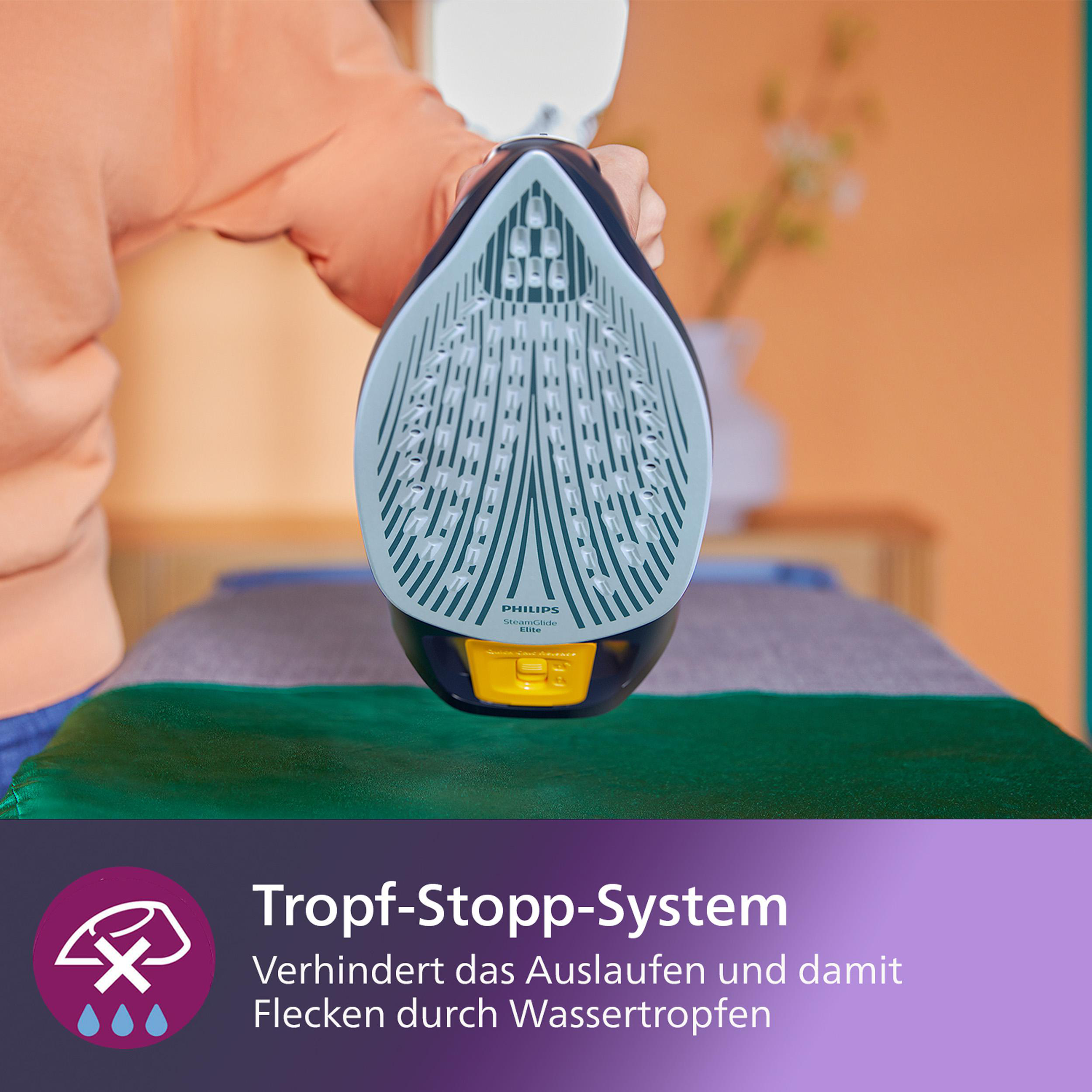 Ein Bügeleisen, das Kleidung auf einem grauen Brett bedampft. Der Boden des Bügeleisens ist sichtbar.