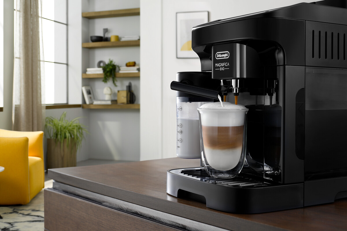 Fekete De'Longhi Magnifica Evo eszpresszógép, amely latte-t készít.