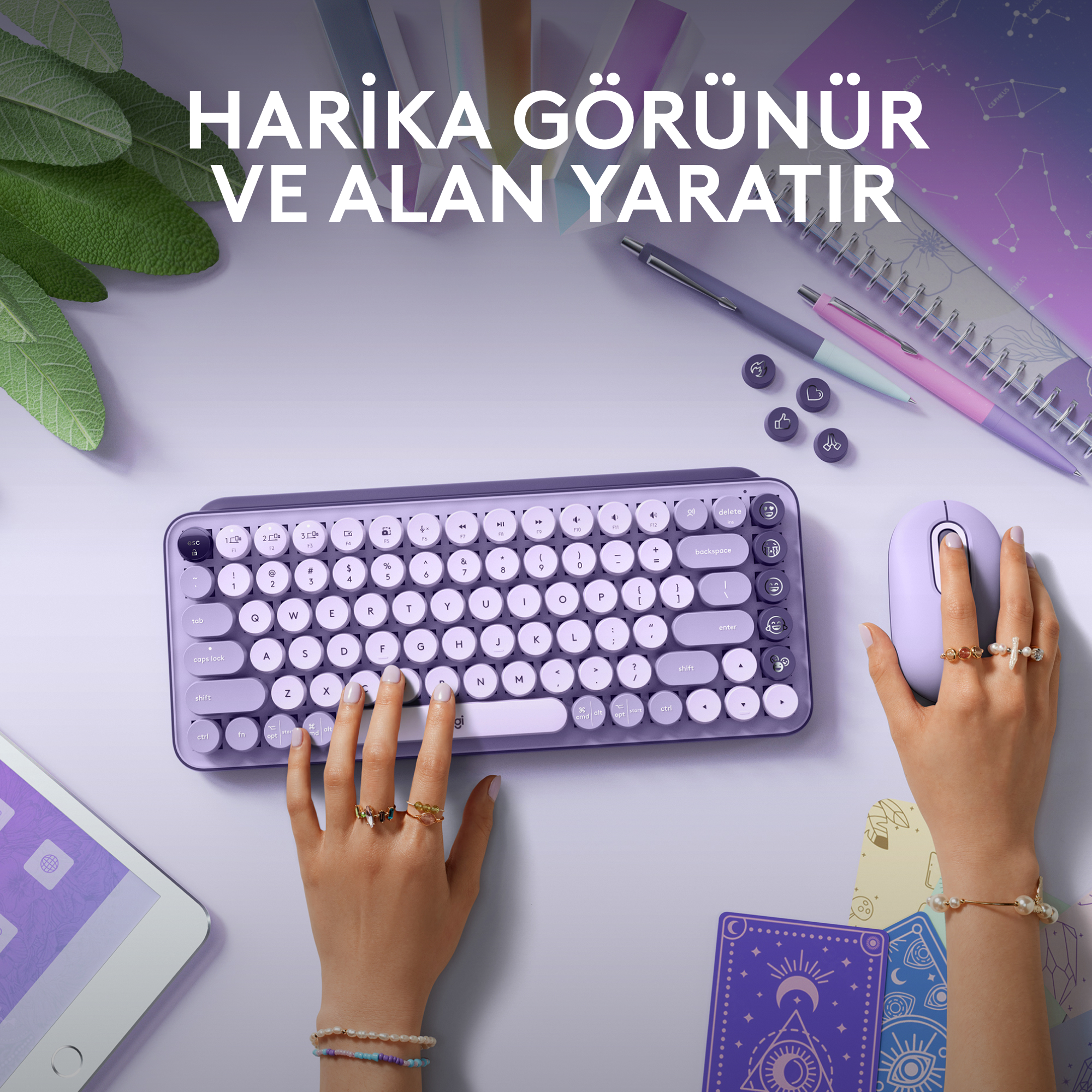 Mor bir masada düzenlenmiş bir klavye, fare ve aksesuarlar.