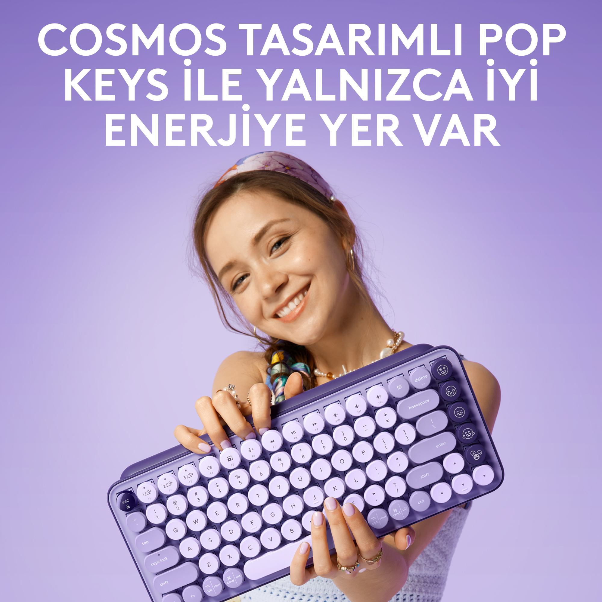 Mor arkaplanda, beyaz tuşlu mor bir klavye tutan, gülen bir kadın.