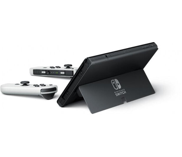 Konsola Nintendo Switch z dwoma białymi kontrolerami. Konsola jest podparta na podstawce.