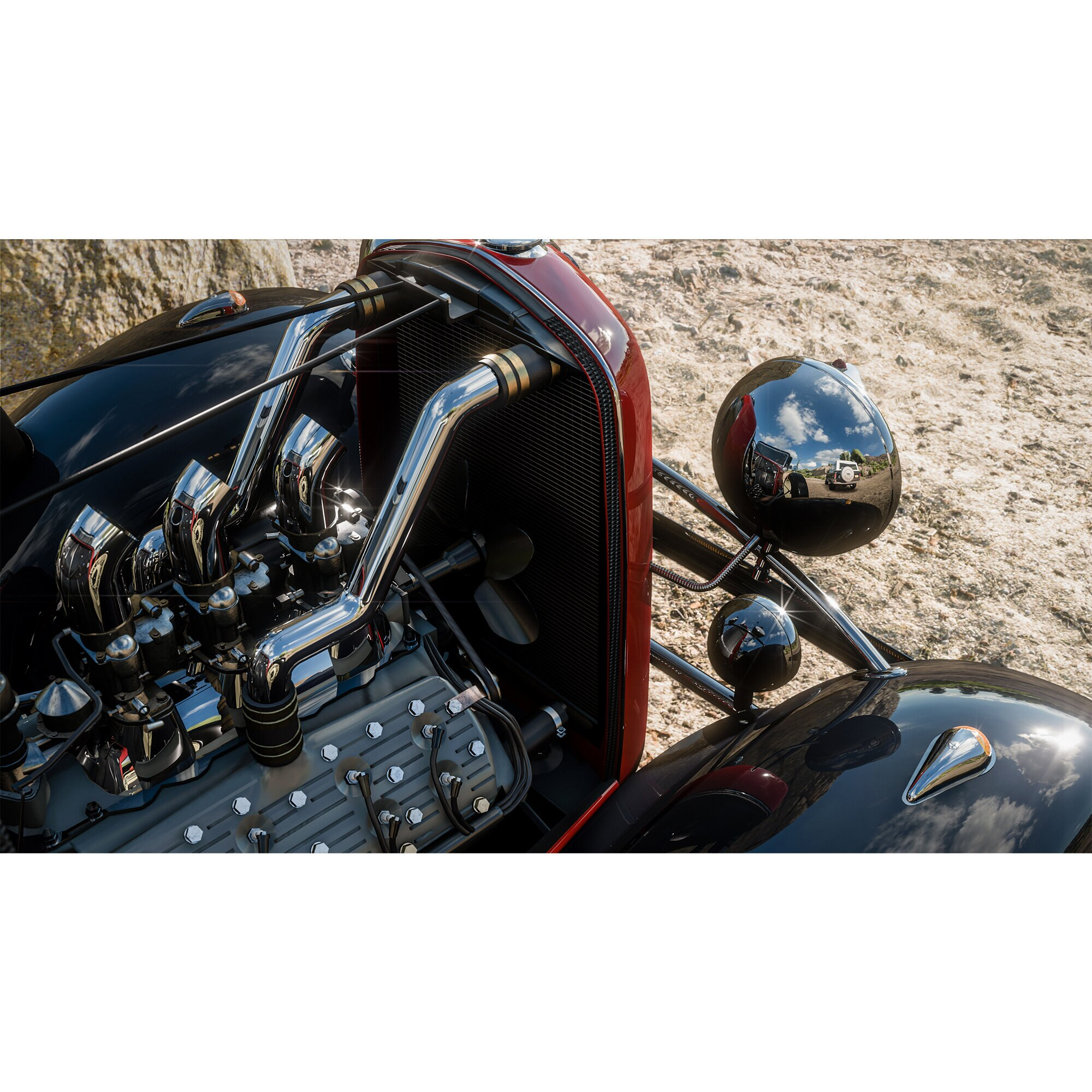 Silnik klasycznego samochodu. Chromowane rury wydechowe, czarny korpus i czerwone detale widoczne.