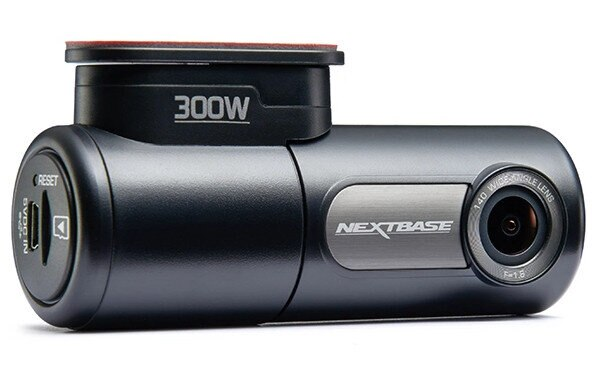 Czarna kamera samochodowa z obiektywem i logo NEXTBASE. Jest ustawiona na białym tle.