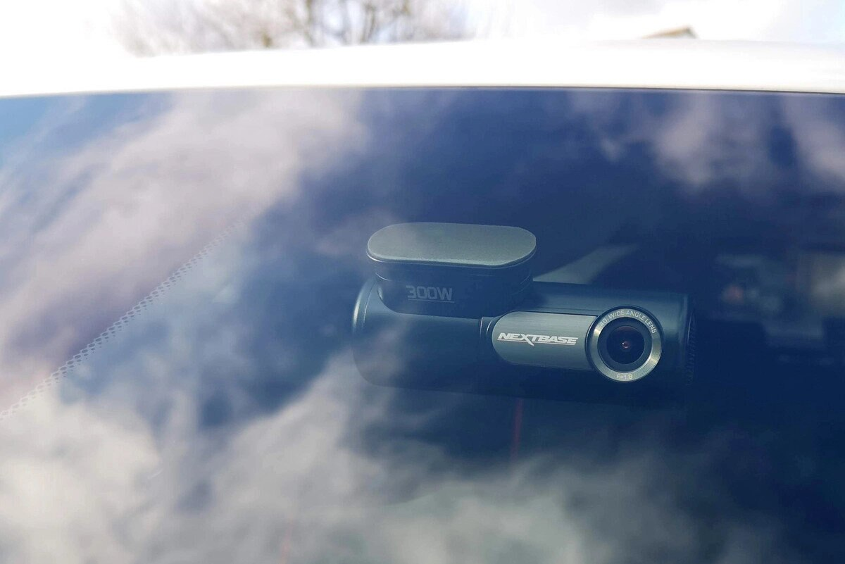 Tylna szyba samochodu z zamontowaną w środku kamerą samochodową. Powierzchnia odblaskowa.