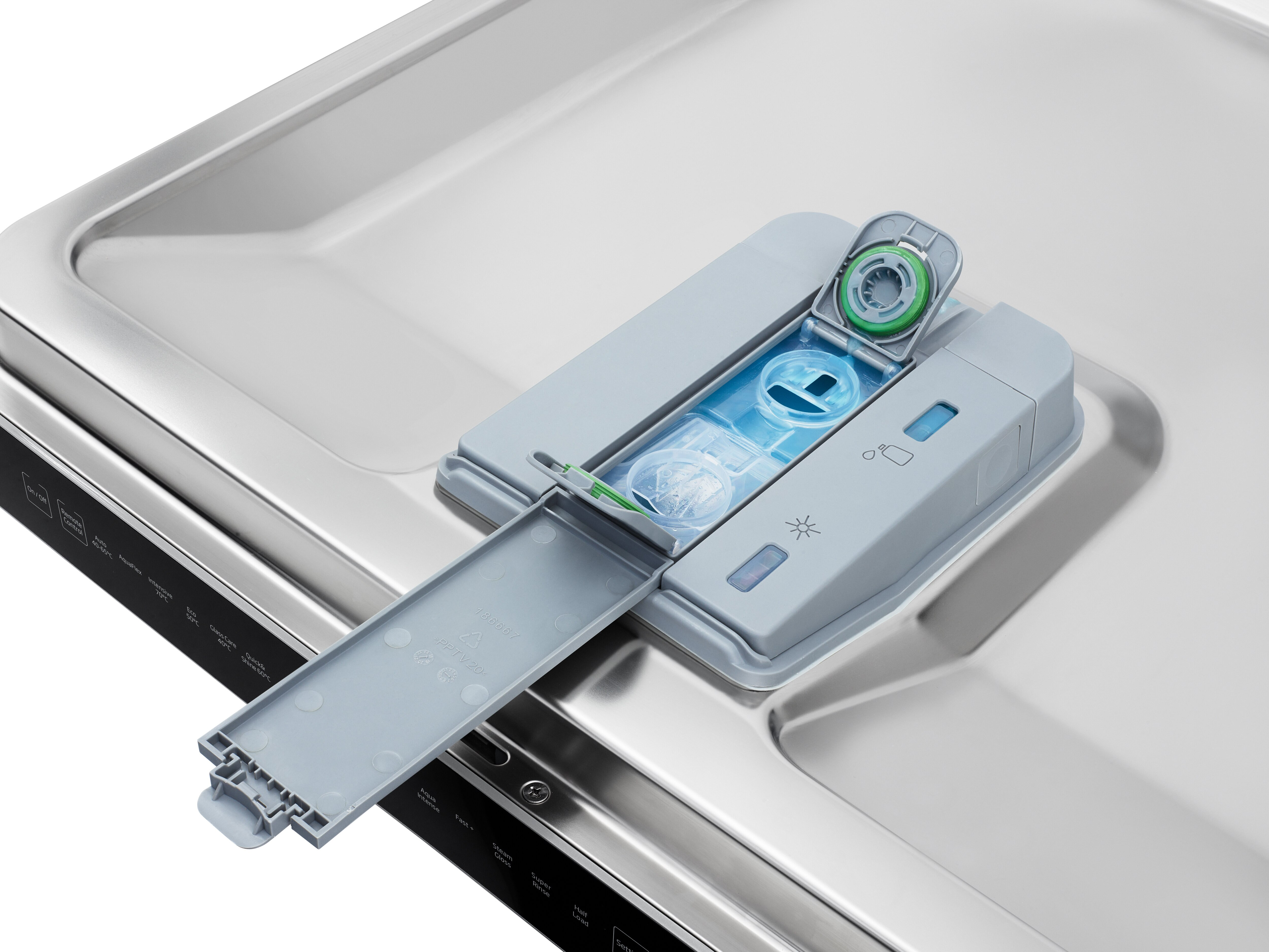 Dozownik detergentu do zmywarki z szarą plastikową pokrywą, otwarty, pokazujący detergent i nabłyszczacz.