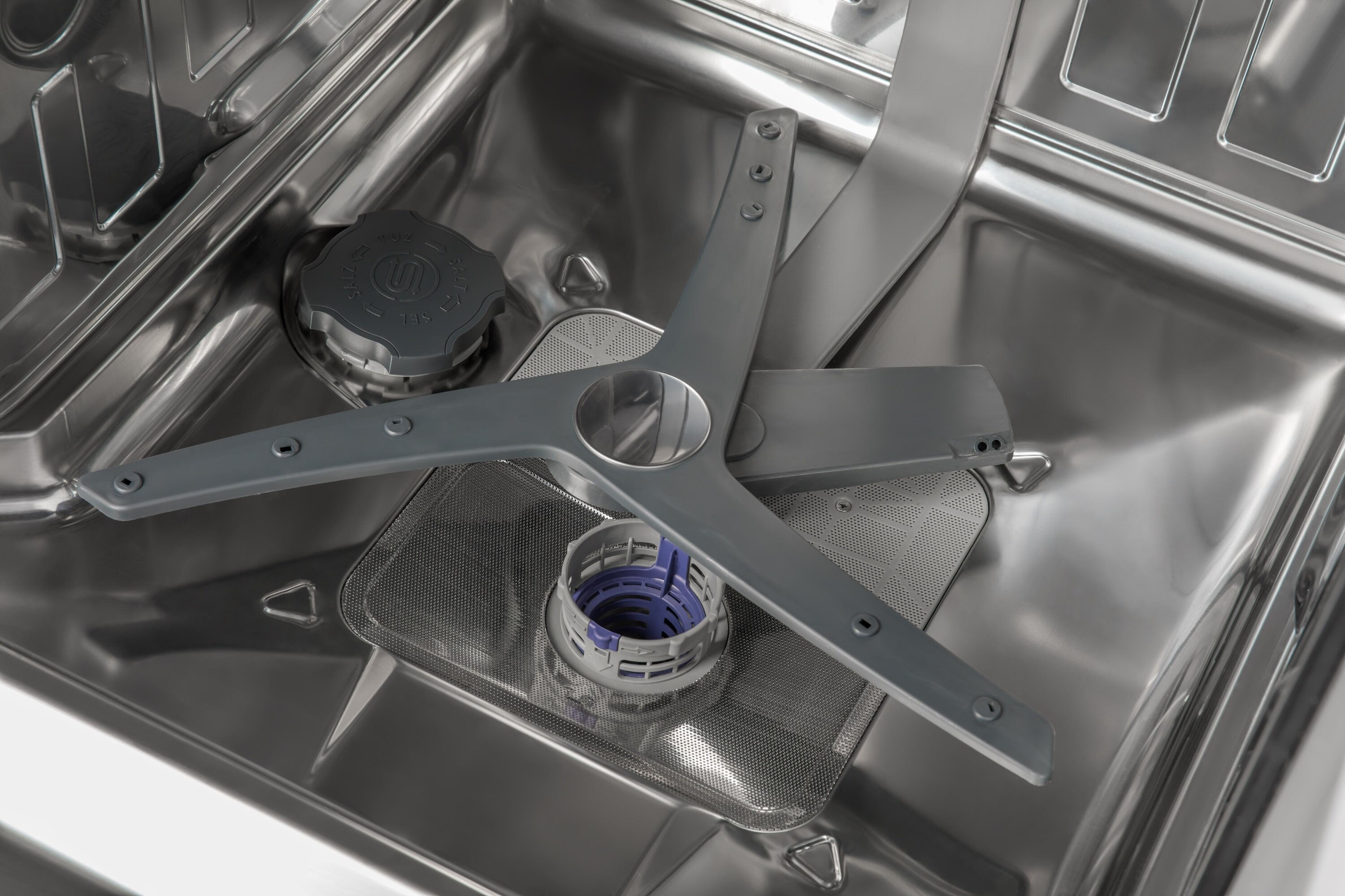 Wnętrze zmywarki z widocznym spryskiwaczem i filtrem.