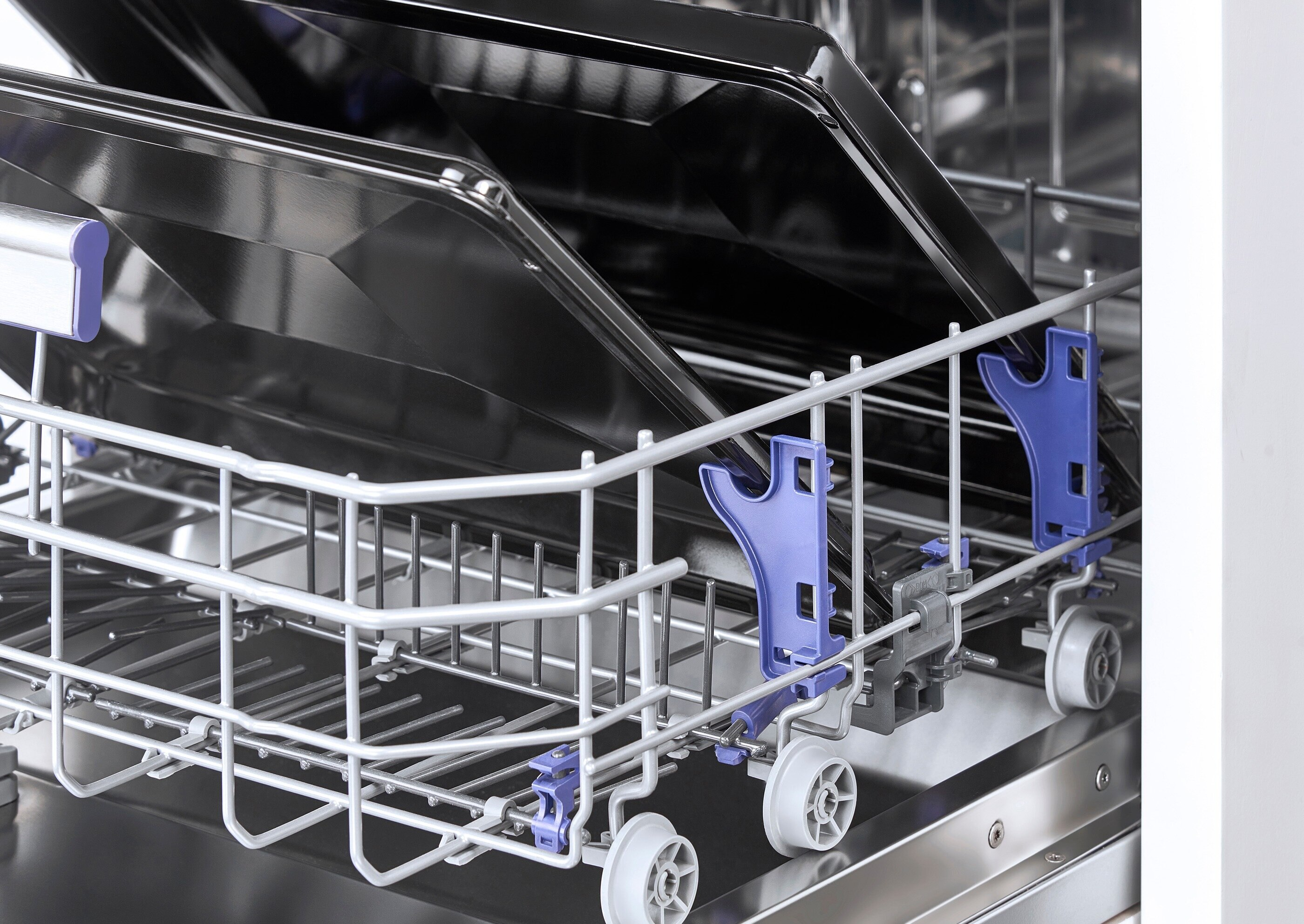 Wnętrze zmywarki z rusztem i dwiema tacami.