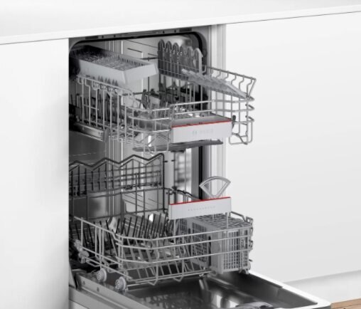 Wnętrze zmywarki z koszami. Na górze sztućce, na dole naczynia.