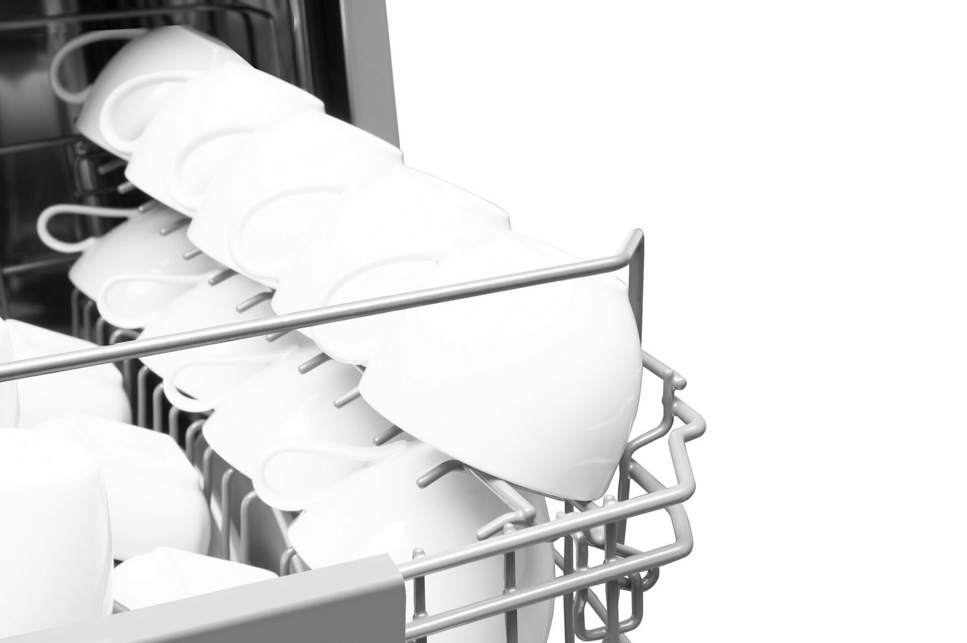 Zbliżenie na stojak zmywarki z uporządkowanymi białymi filiżankami.