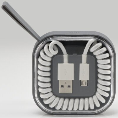 Kwadratowe etui z białymi kablami USB w środku. Przezroczysta pokrywa, szara ramka.