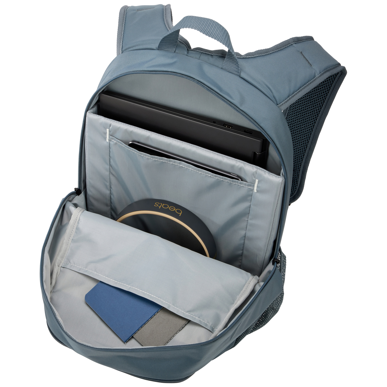 A backpack open, with a laptop, tablet, and headphones inside.