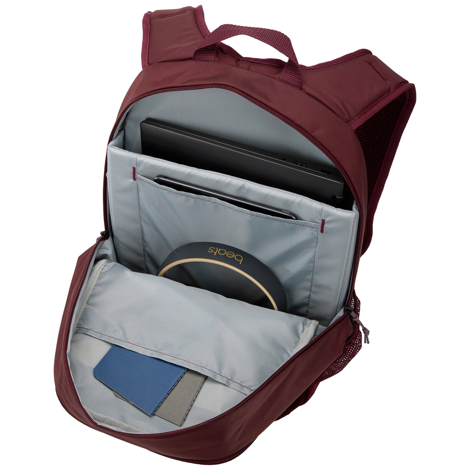Burgundy backpack open with a laptop, tablet, and headphones inside.