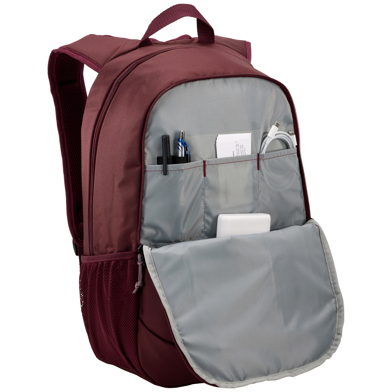 Maroon backpack with open front pocket. Items inside: pens, papers, a cable, and a white power bank.