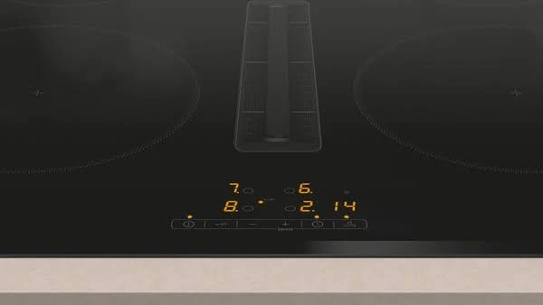 Primer plano de una encimera negra con controles digitales, mostrando números y símbolos.