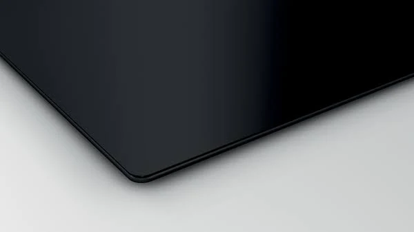 Primer plano de placa de cocina negra de vidrio, diseño limpio.
