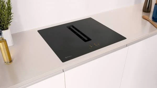 Encimera negra con ventilación incorporada, mostrando un diseño de cocina limpio y moderno.