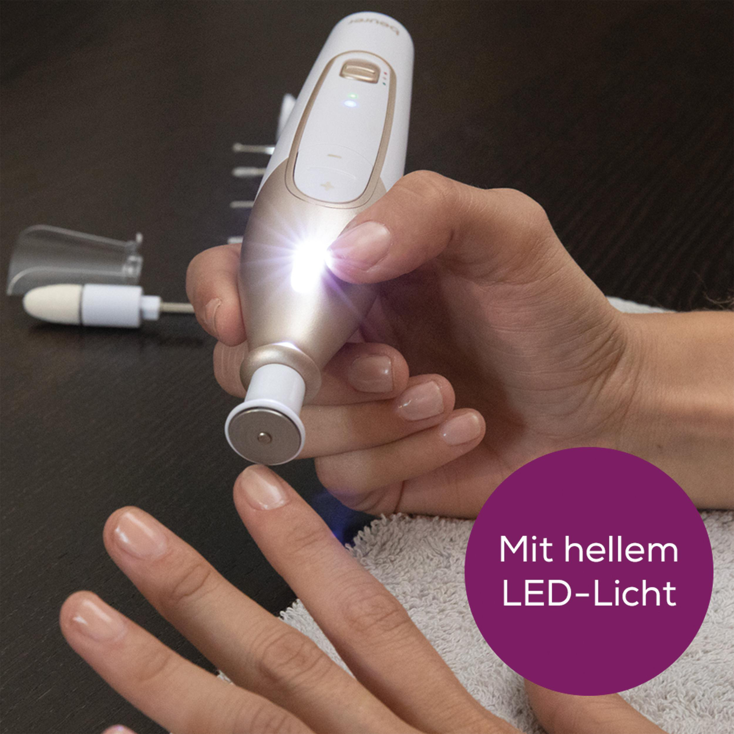 Eine Hand hält ein Nagelpflegegerät mit hellem LED-Licht. Die Nägel sind manikürt.