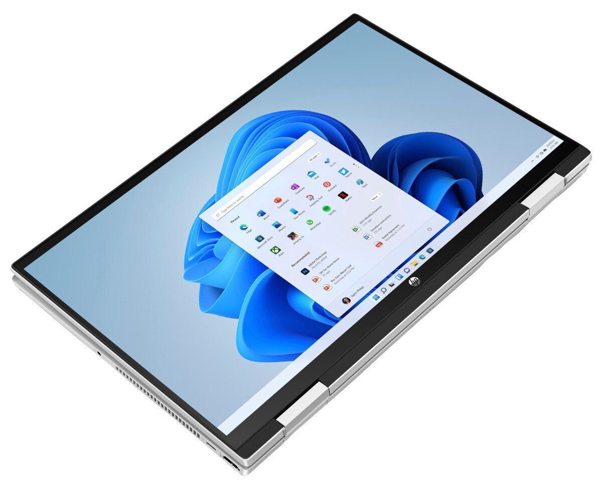 Laptop, otwarty, pokazujący menu Windows na ekranie. Tło jest jasnoniebieskie.