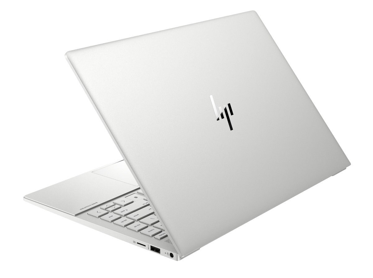 Srebrny laptop jest otwarty, pokazując klawiaturę i logo na górze. Tło jest białe.
