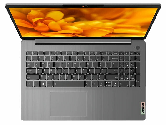 Otwarty laptop, szary korpus, klawiatura widoczna, ekran z pomarańczowym tłem kwiatowym.