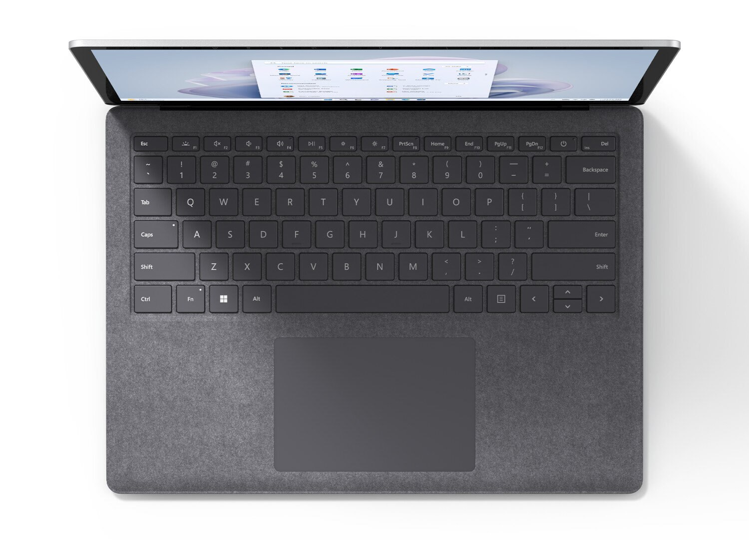 Laptop otwarty, widok z góry. Czarna klawiatura i gładzik. Białe tło.