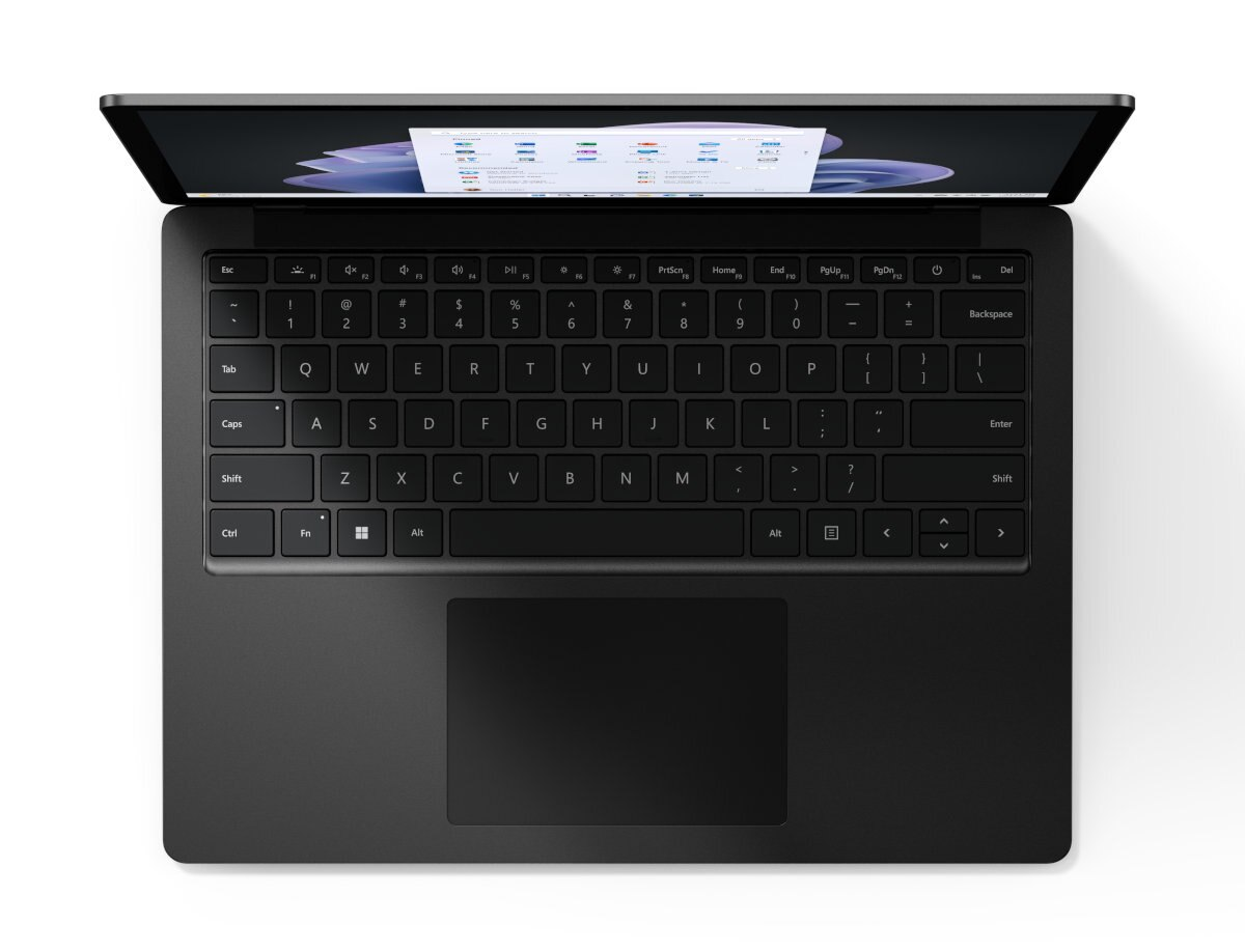 Widok z góry na czarny laptop, wyświetlający ekran z danymi, białe tło.