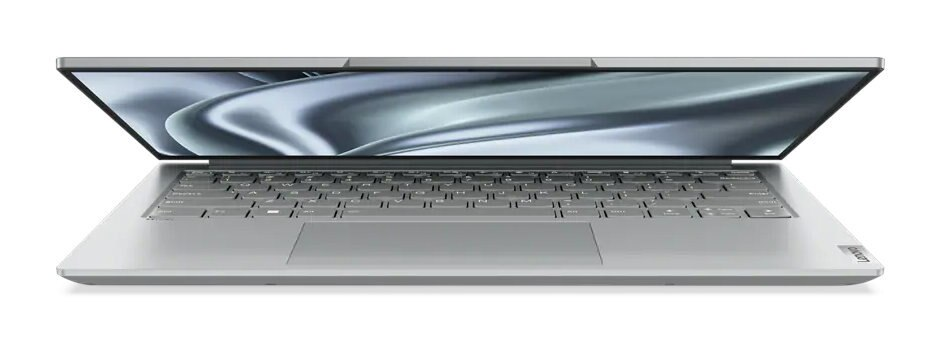 Srebrny laptop, otwarty, pokazujący klawiaturę i ekran. Białe tło.