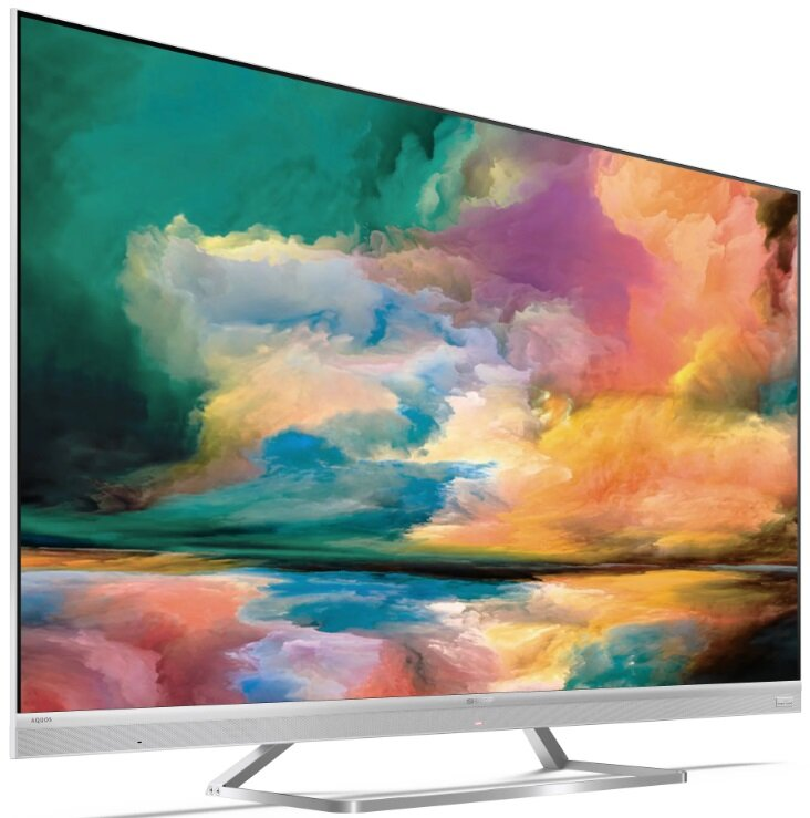 Duży telewizor Sharp z kolorową, abstrakcyjną ekspozycją artystyczną. Srebrna ramka i stojak.