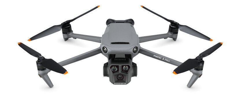 Szary dron Mavic 3 Pro, cztery śmigła, kamera. Białe tło.