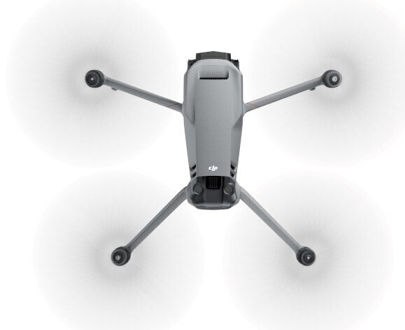 Szary dron DJI z obracającymi się śmigłami. Widok od dołu, pokazuje konstrukcję drona.