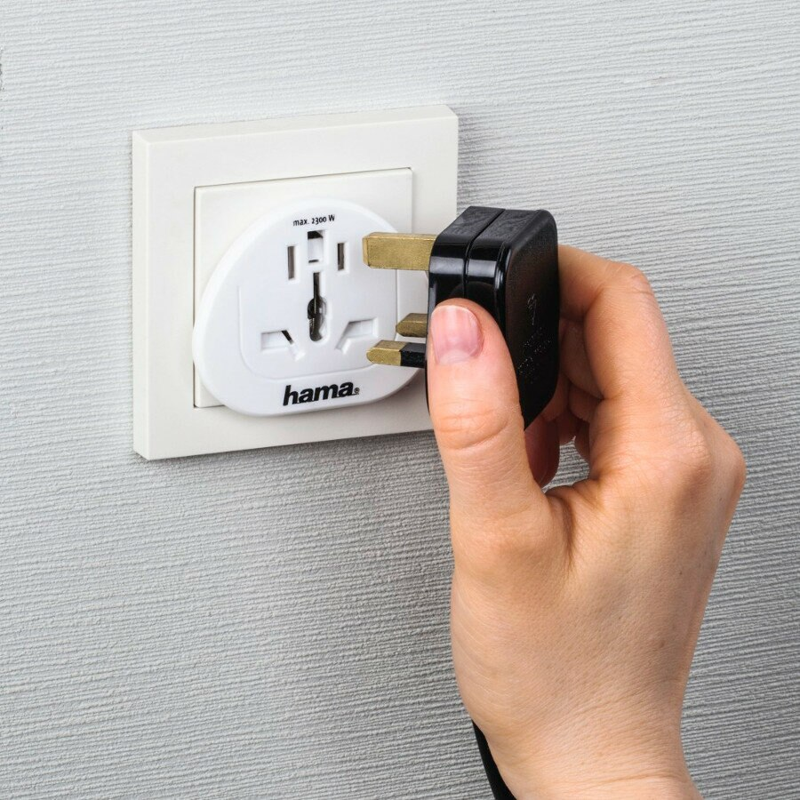 Ręka wkłada czarną wtyczkę do białego adaptera Hama. Maks. 2300W.