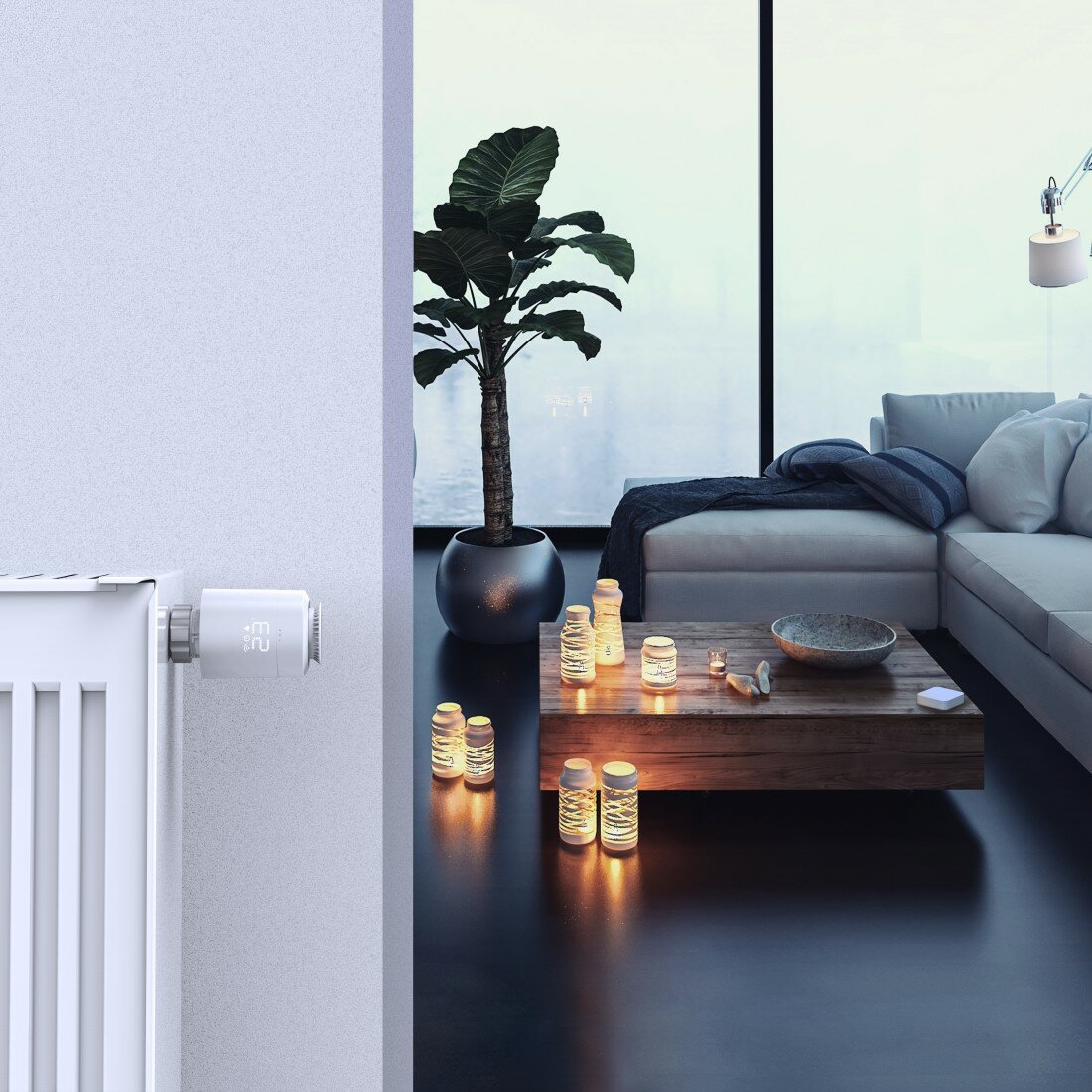 Nowoczesny salon z inteligentnym termostatem na ścianie i świecami.