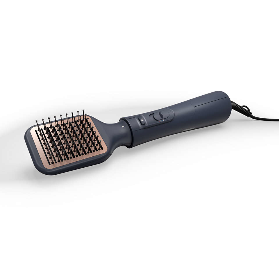 Hair styling brush, dark grey handle, rose gold bristles, on white background.